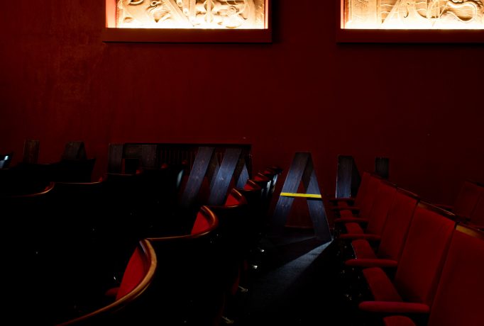 red cinema seats in front of wooden letters